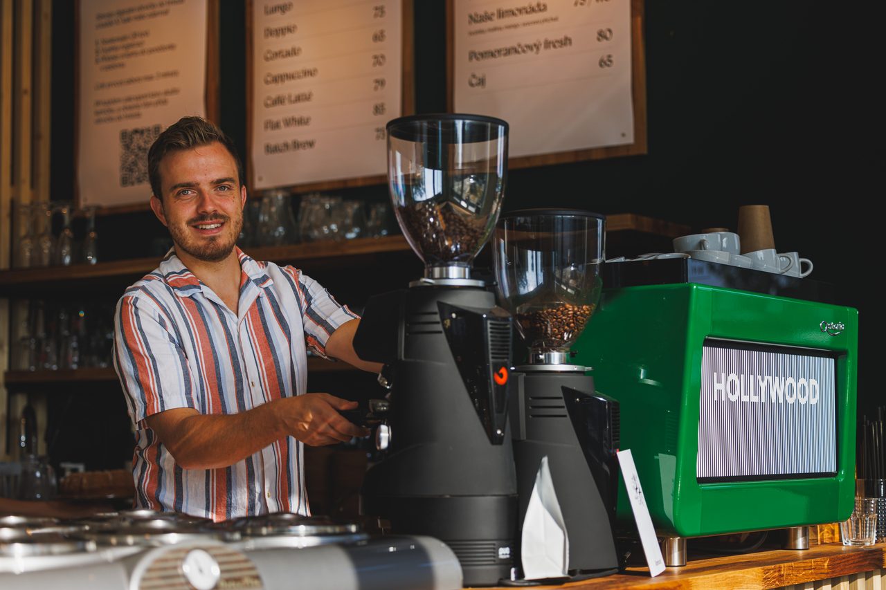 Barista u kávovaru Astoria Hollywood v showroomu Prais